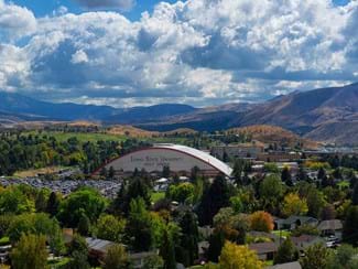 A view of Iowa State University Indoor Stadium with the mountains behind in Pocatello, ID