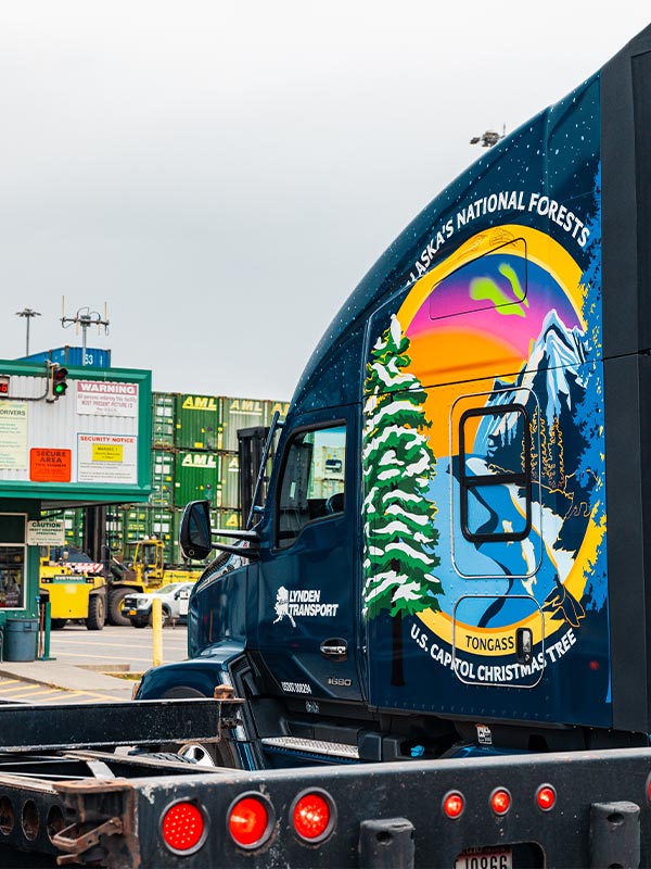 Capitol Christmas Tree Custom Kenworth Truck in front of shipping containers